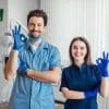 photo smiling dentist standing with arms crossed with her colleague showing okay sign