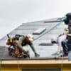 Everett WA. USA - 03-23-2021: Crew Installing New Shingles on Roof on a Rainy Day