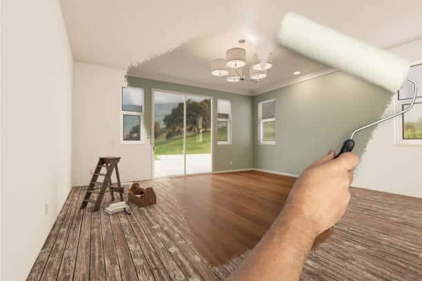 Before and After of Man Painting Roller to Reveal Newly Remodeled Room with Fresh Light Green Paint and New Floors.