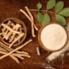 Ashwagandha superfood powder and root on cutting board on wooden table from above. Adaptogen.