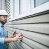 Building inspector at work. He is inspecting the windows of a residential building.