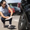 Woman inspector writing in documents on clipboard near broken car. Auto insurance concept