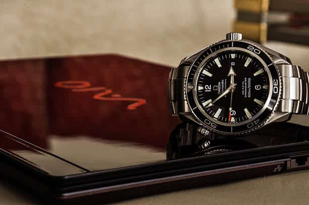 Munich, Germany - January 8, 2011: Omega Seamaster Planet Ocean wristwatch lying on a Sony VAIO laptop.