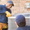 Multi-ethnic team of blue collar air conditioner repairmen at work. They prepare to begin work by gathering appropriate tools from their tool box.