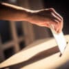 Conceptual image of a person voting, casting a ballot at a polling station, during elections.