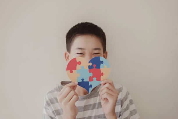 Preteen boy holding puzzle jigsaw, child mental health concept, world autism awareness day, teen autism spectrum disorder awareness concept