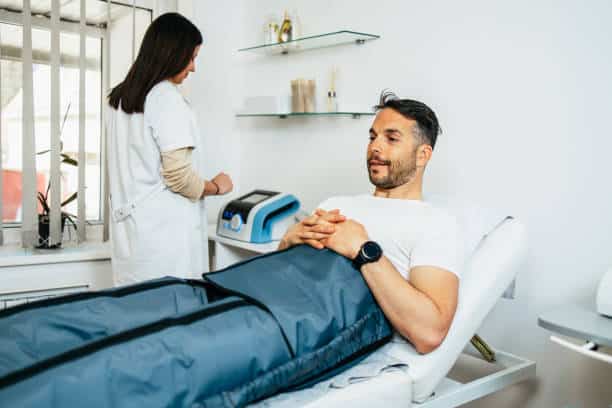 Handsome middle aged sporty man receiving modern physiotherapy treatment. Modern medicine concept.