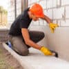 worker applies bitumen mastic on the foundation