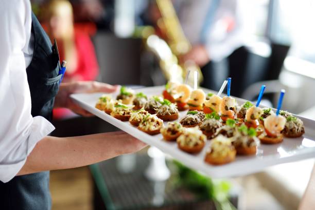 Waiter carrying plates with meat dish on some festive event, party or wedding reception