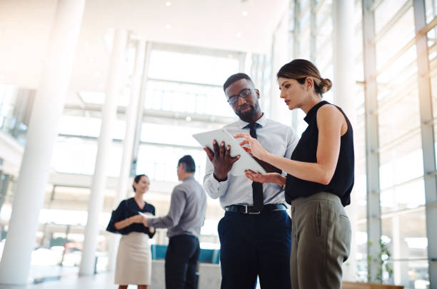 Shot of a young businessman and businesswoman using a digital tablet at a conference